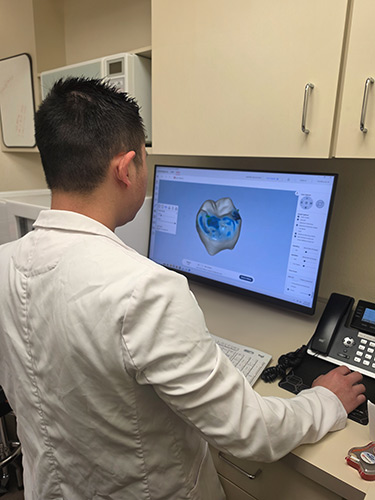 Dr. Loo designing a custom same-day crown on a digital monitor
